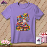 A purple t-shirt displays a graphic of a colorful gnome holding a tall stack of folded fabrics.