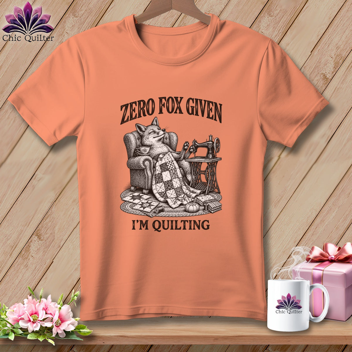 Peach t-shirt with a fox on a chair, sewing machine, and text "ZERO FOX GIVEN I'M QUILTING".
