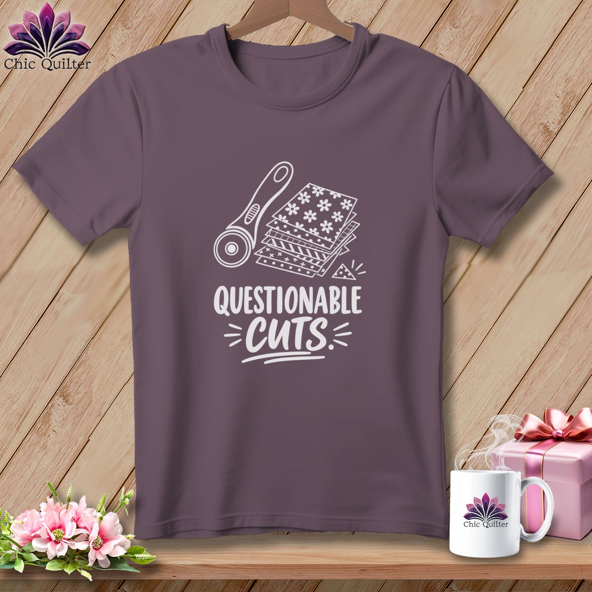 T-shirt with rotary cutter and fabric stack graphic, "Questionable Cuts" text.