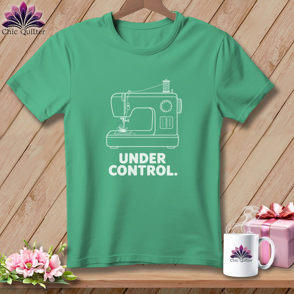 Green t-shirt with white line art of a sewing machine and text "UNDER CONTROL."