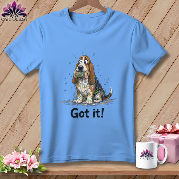 Light blue t-shirt with a cartoon basset hound tangled in colorful yarn, with text "Got it!".