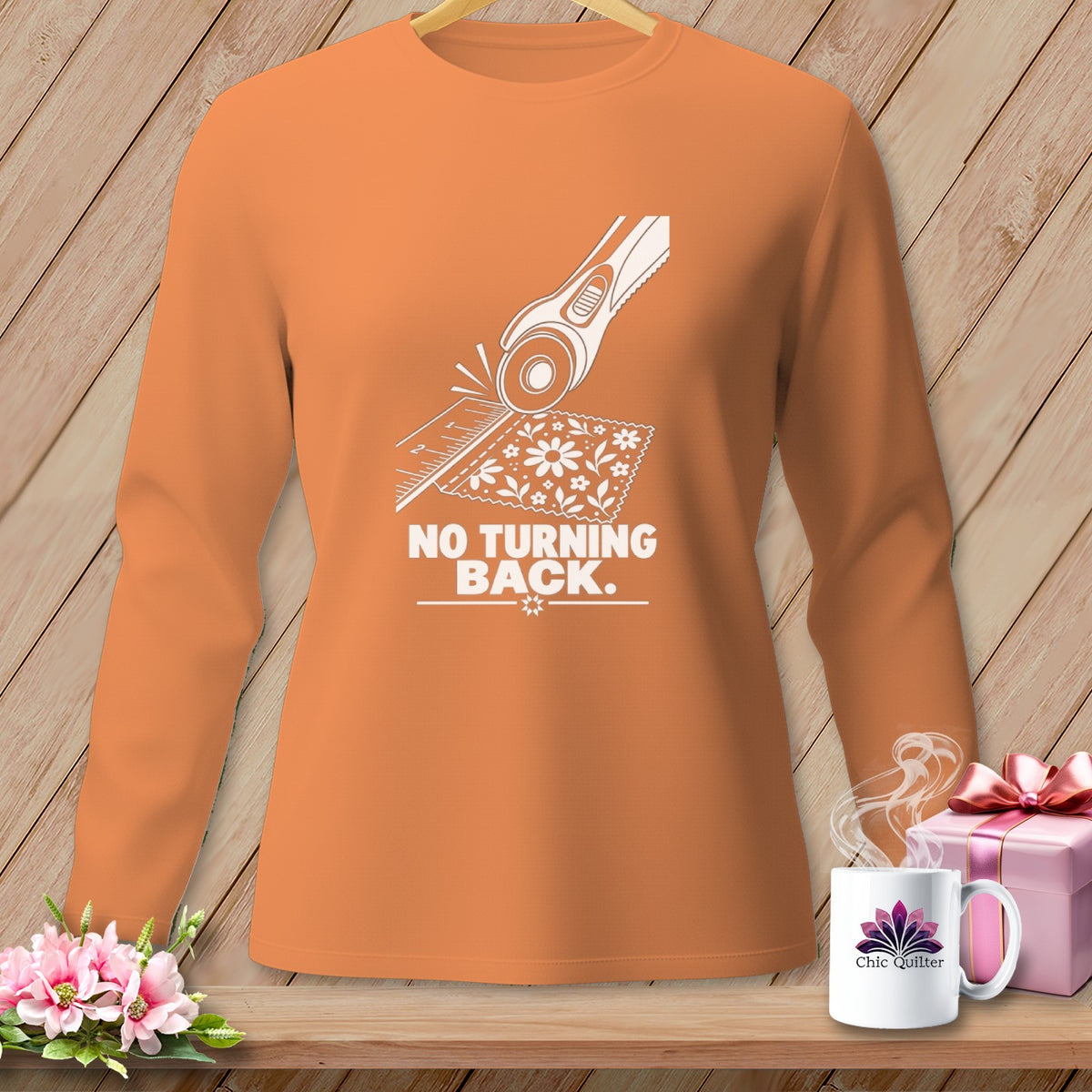 Orange long-sleeve shirt with a white graphic of a rotary cutter and fabric, saying "NO TURNING BACK."