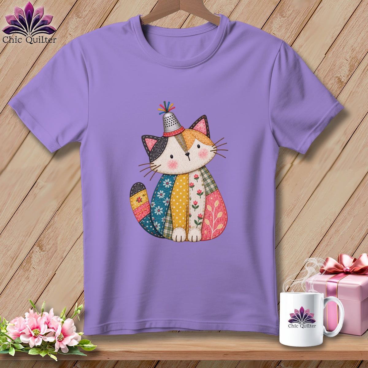 Purple short-sleeved t-shirt hanging on a wooden wall, featuring a patchwork cat graphic wearing a thimble hat.