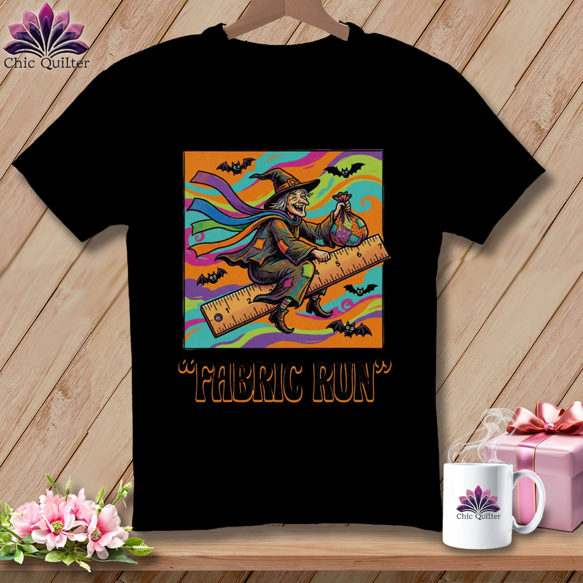 Black t-shirt with a witch riding a ruler, text "FABRIC RUN", and bats.