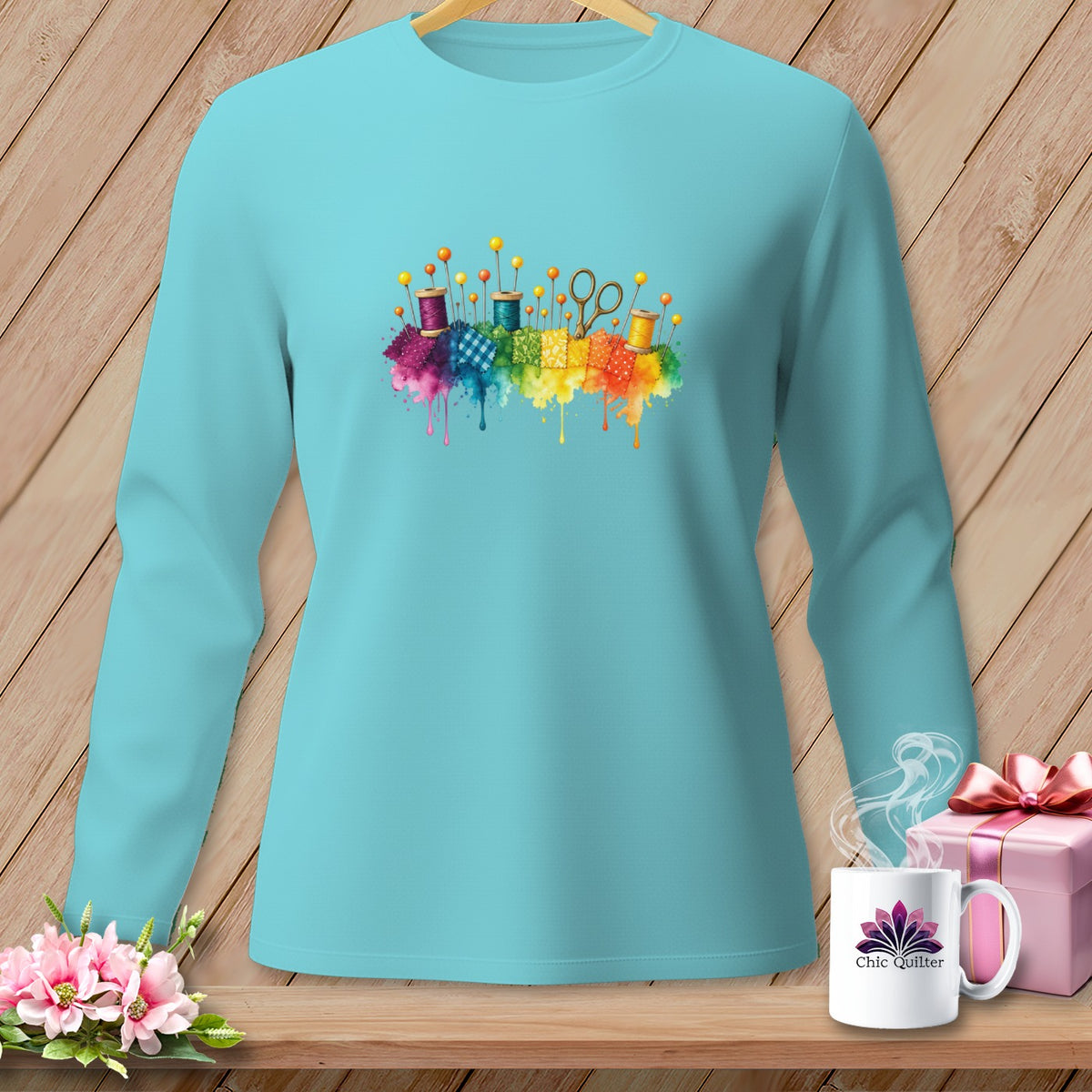 Teal long-sleeve shirt with watercolor sewing notions and rainbow fabric splashes.