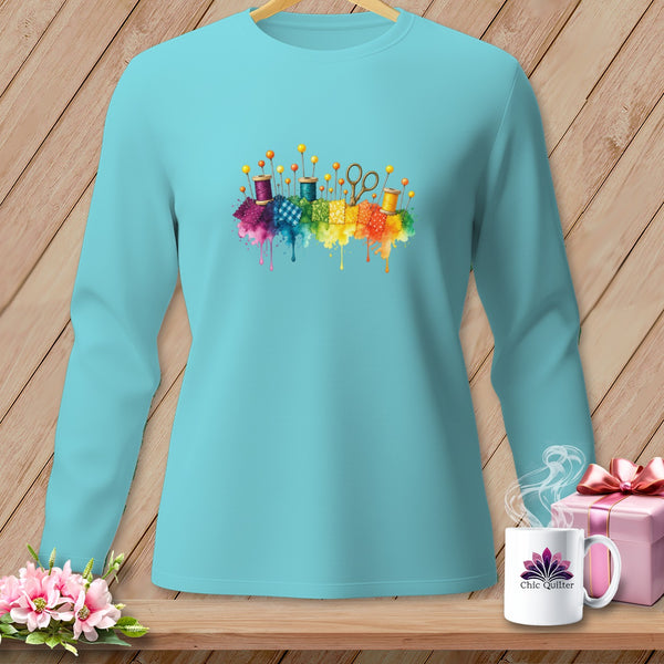 Teal long-sleeve shirt with watercolor sewing notions and rainbow fabric splashes.