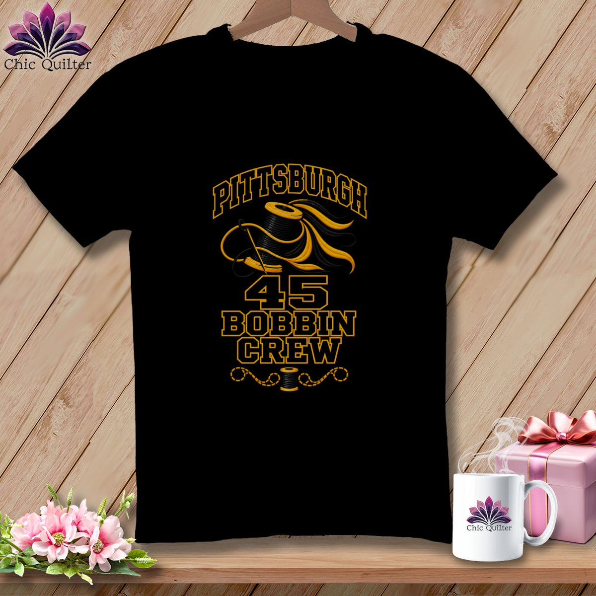 Black t-shirt featuring a yellow graphic of a spool of thread, needle, and text reading Pittsburgh Bobbin Crew.