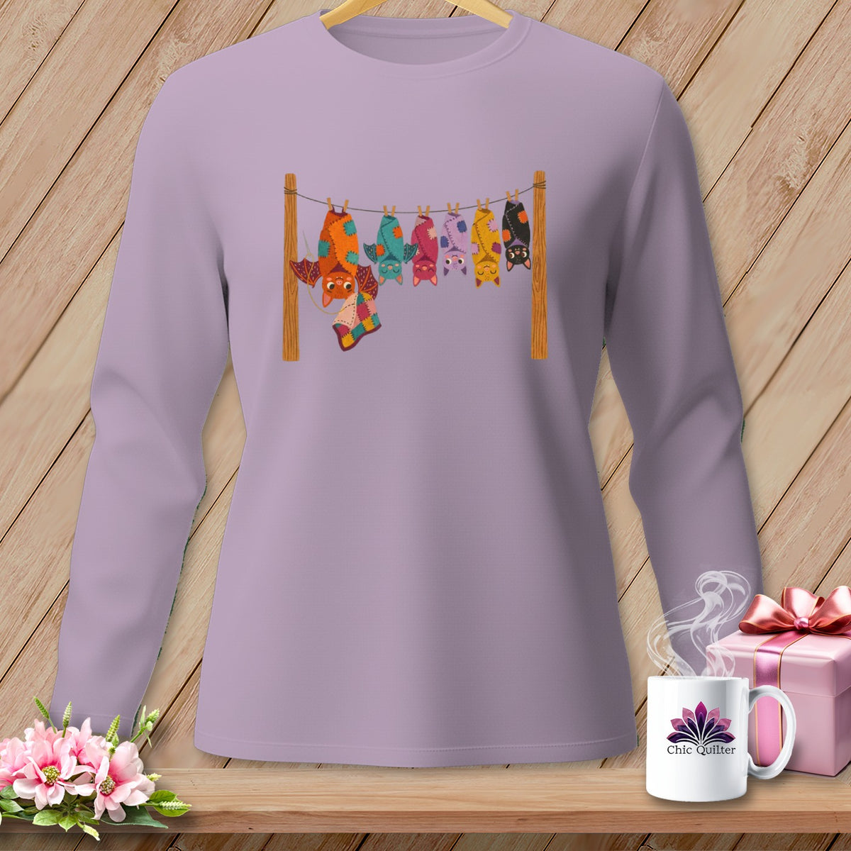 Long-sleeve lilac shirt with colorful quilted bats hanging on a clothesline.