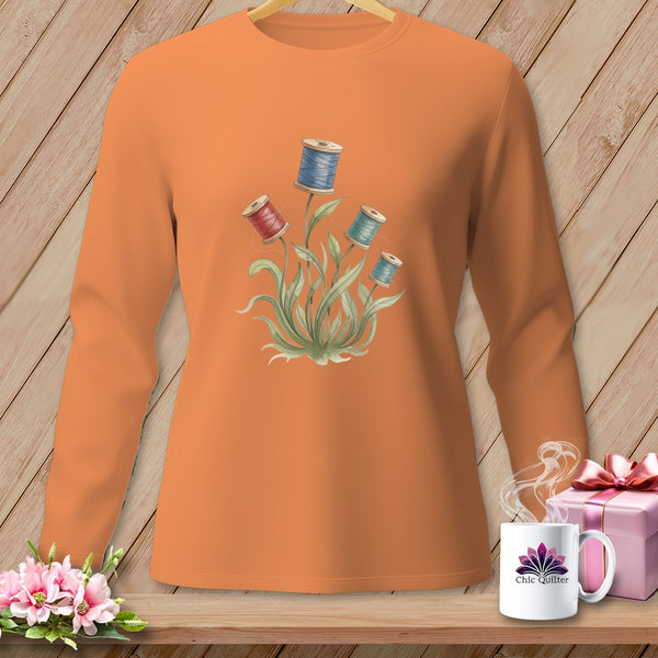 Orange sweatshirt with watercolor spool of thread floral print and "Chic Quilter" mug.