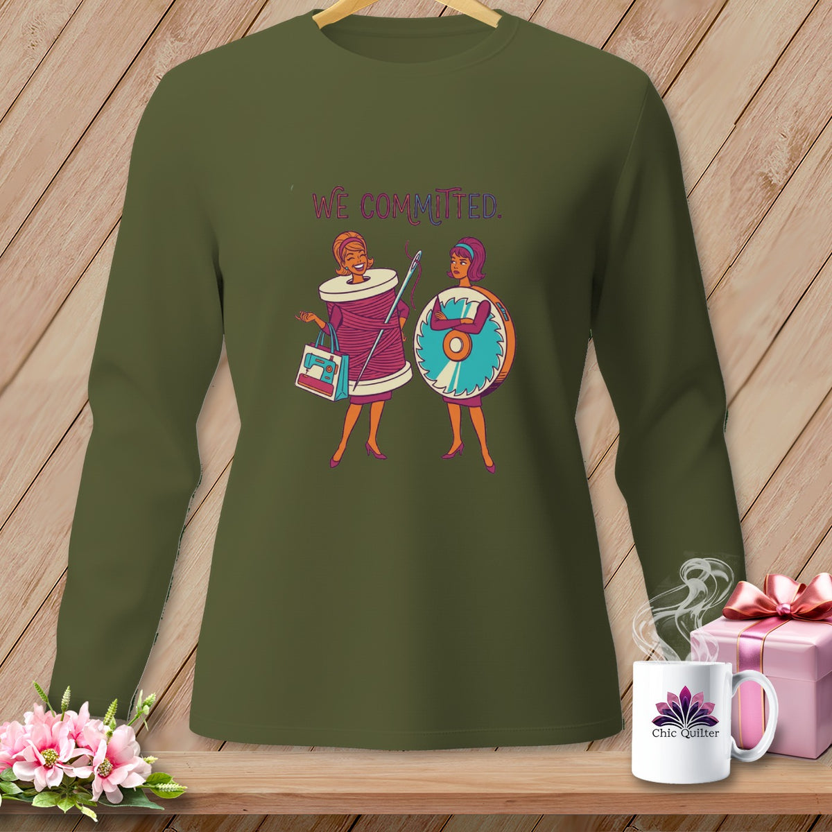 Olive green long-sleeved shirt with "We Committed" text and sewing-themed illustrations.
