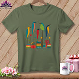 Olive green t-shirt featuring a graphic print of colorful stylized birds perched on sewing-themed elements.
