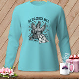 Long-sleeve turquoise shirt with a chicken sewing a quilt graphic and text 