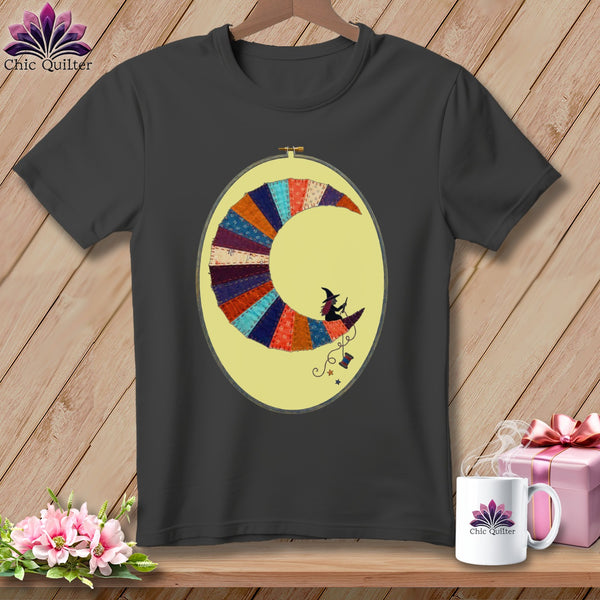 Dark gray t-shirt with a crescent moon made of colorful fabric scraps and two witches.