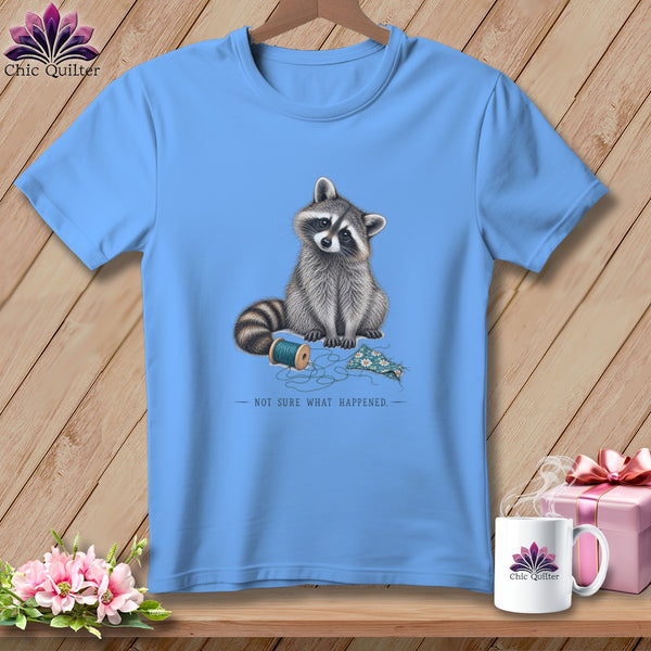 Light blue t-shirt with raccoon illustration, spool of thread, and text "NOT SURE WHAT HAPPENED."