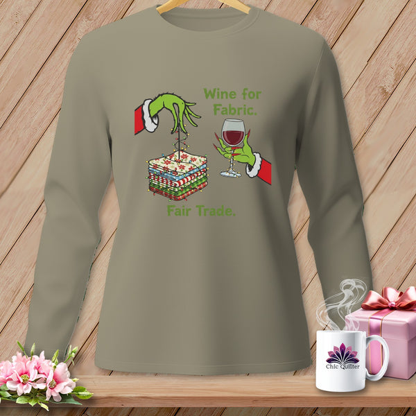 Green Grinch hands hold fabric and wine with text "Wine for Fabric. Fair Trade."