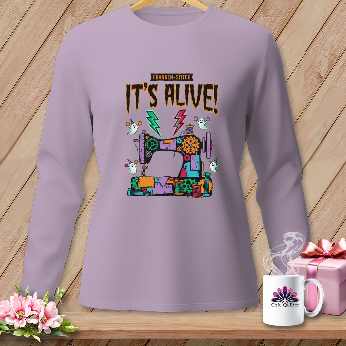 Long-sleeve shirt with a Franken-stitch sewing machine and ghosts graphic that says "IT'S ALIVE!".