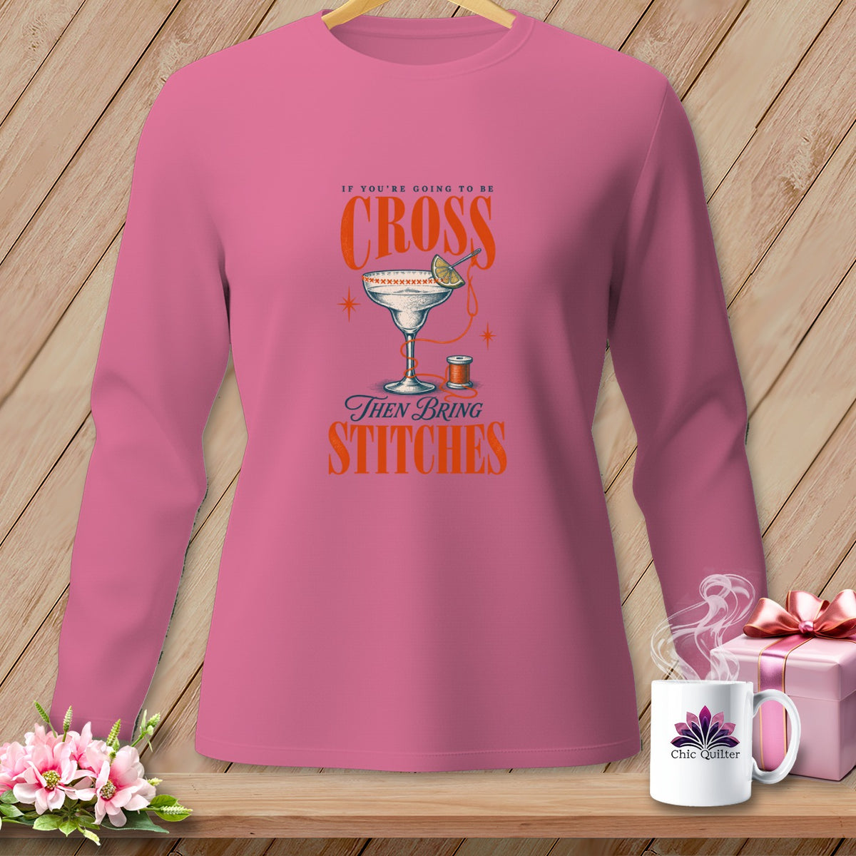 Pink long-sleeve shirt with "If You're Going to Be Cross Then Bring Stitches" graphic.