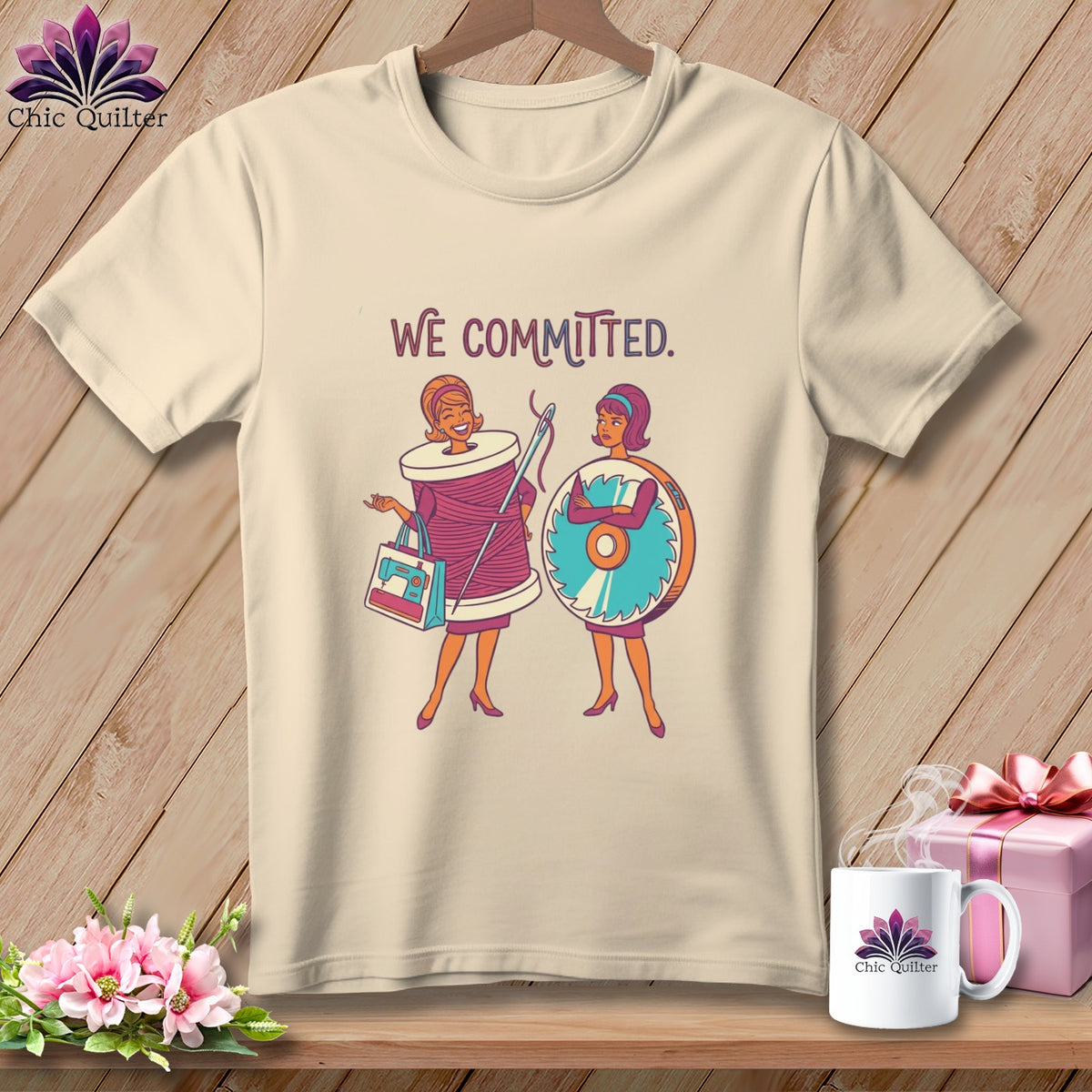 T-shirt with "WE COMMITTED" graphic featuring two women, one a spool of thread and the other a rotary cutter.