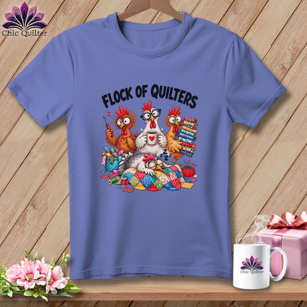 Periwinkle t-shirt featuring a cartoon illustration of four chickens and the text Flock of Quilters.