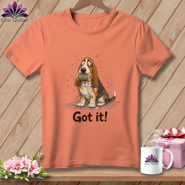 Orange t-shirt with a cartoon basset hound tangled in colorful threads, with "Got it!" text.