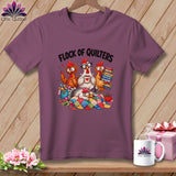 Mauve t-shirt featuring a cartoon design of four chickens quilting with the text Flock of Quilters.