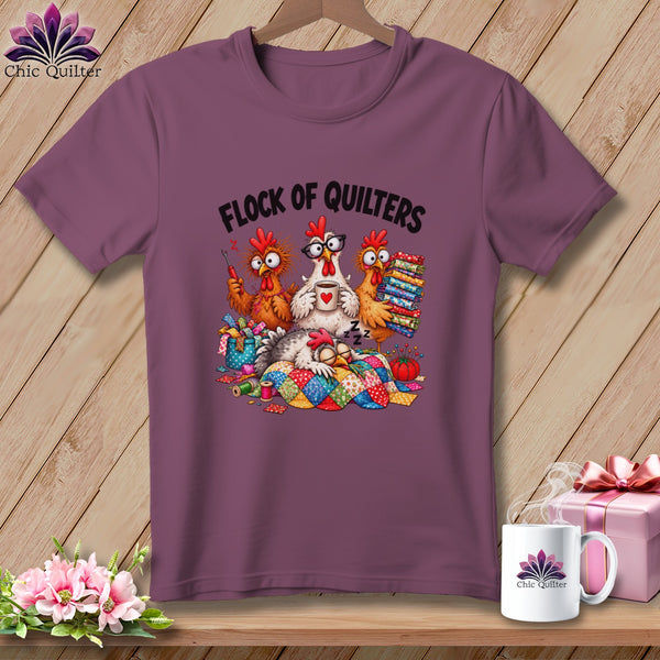 Mauve t-shirt featuring a cartoon design of four chickens quilting with the text Flock of Quilters.
