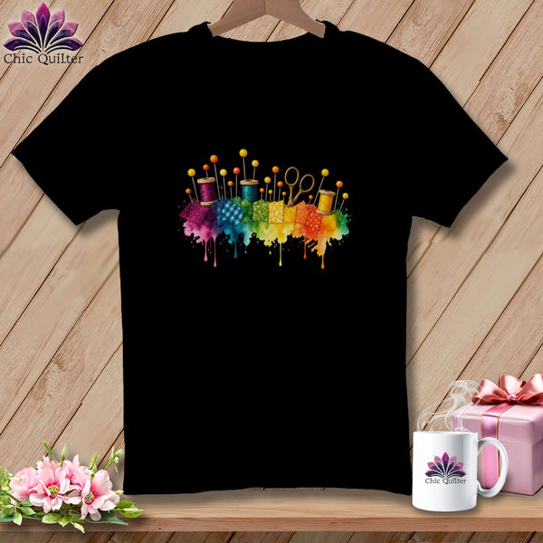 Black t-shirt with colorful sewing supplies and rainbow watercolor splash design.