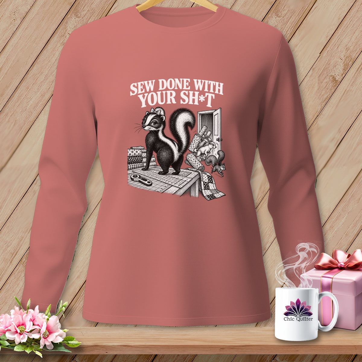 Skunk graphic with text "Sew Done With Your Sh*t" on a mauve long-sleeved shirt.
