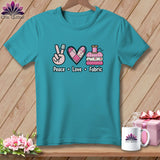 Teal t-shirt featuring a peace sign, quilted heart, and thread spool with the text Peace Love Fabric.
