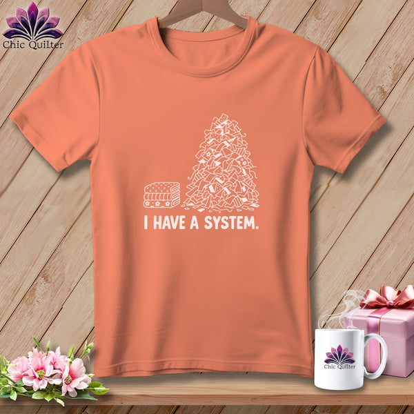 Orange t-shirt with a pile of fabric scraps and the text "I HAVE A SYSTEM."