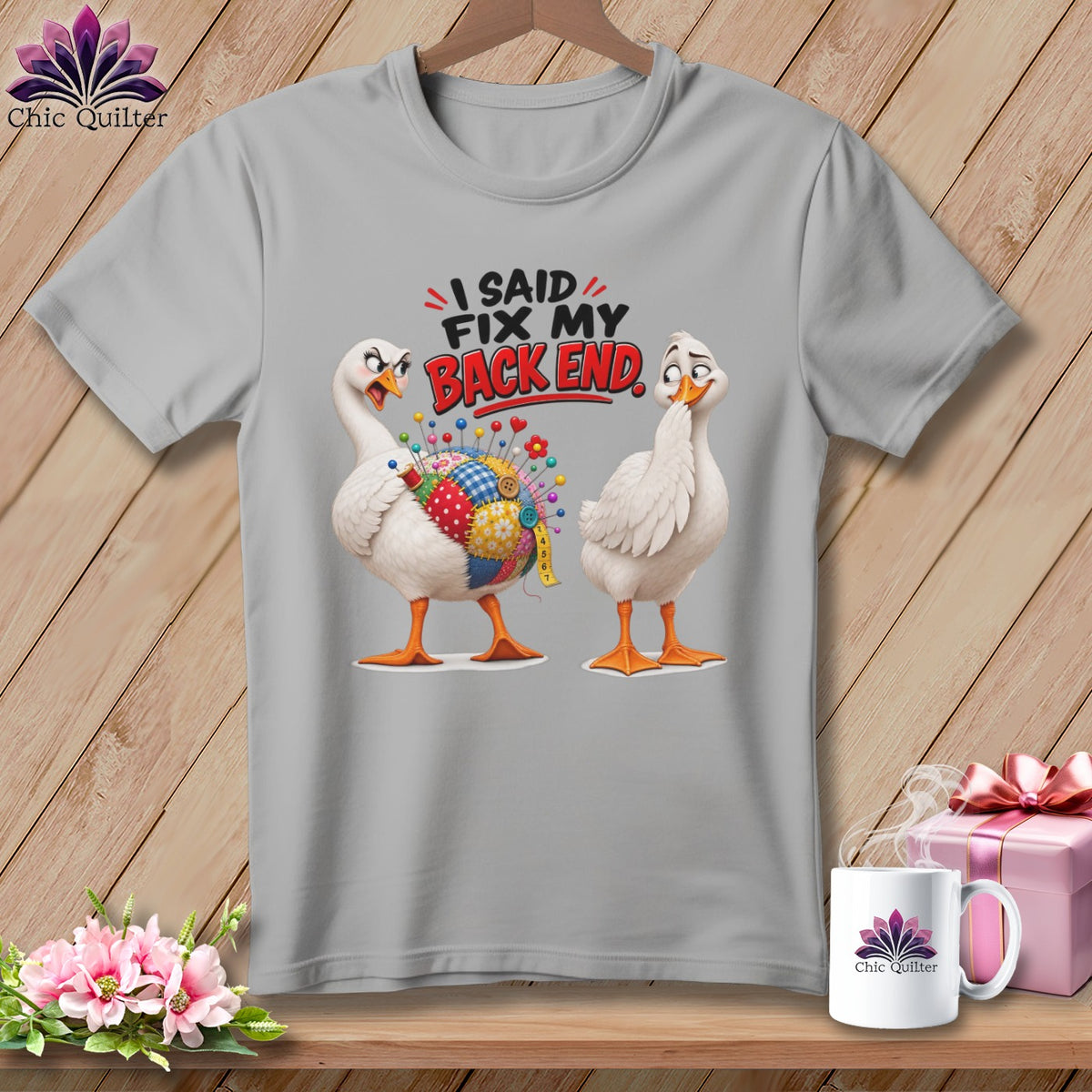 Two cartoon geese on a grey t-shirt, one with a patchwork pincushion body.