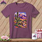 Plum-colored t-shirt featuring a desert landscape graphic with a saguaro cactus, mountains, and rolled quilts.