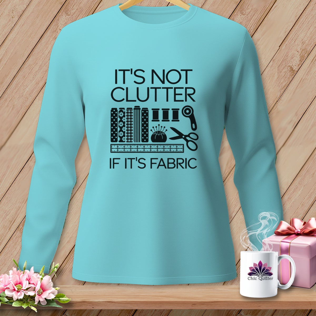 Teal long-sleeve shirt with "It's Not Clutter If It's Fabric" graphic.