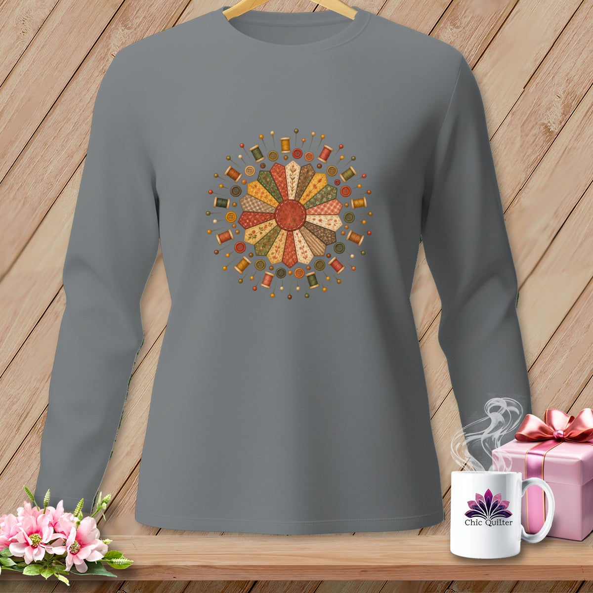 Gray long-sleeve shirt with a radial quilt flower design of spools and pins.