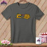 Dark gray t-shirt featuring a yellow sewing machine and a yellow quilt with a red heart.