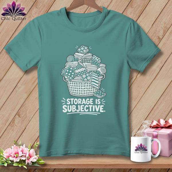 Teal t-shirt with basket of fabric scraps and "STORAGE IS SUBJECTIVE" text.
