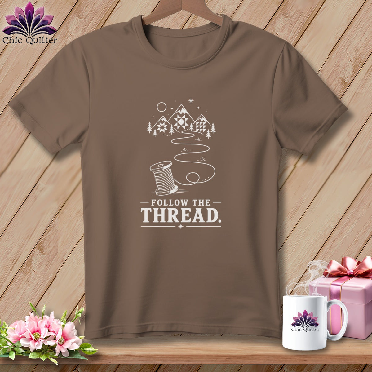 Brown t-shirt with white graphic of spool of thread and "Follow the Thread" text.