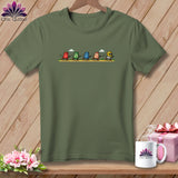 An olive green t-shirt with a graphic of five animated thimbles running across a path.