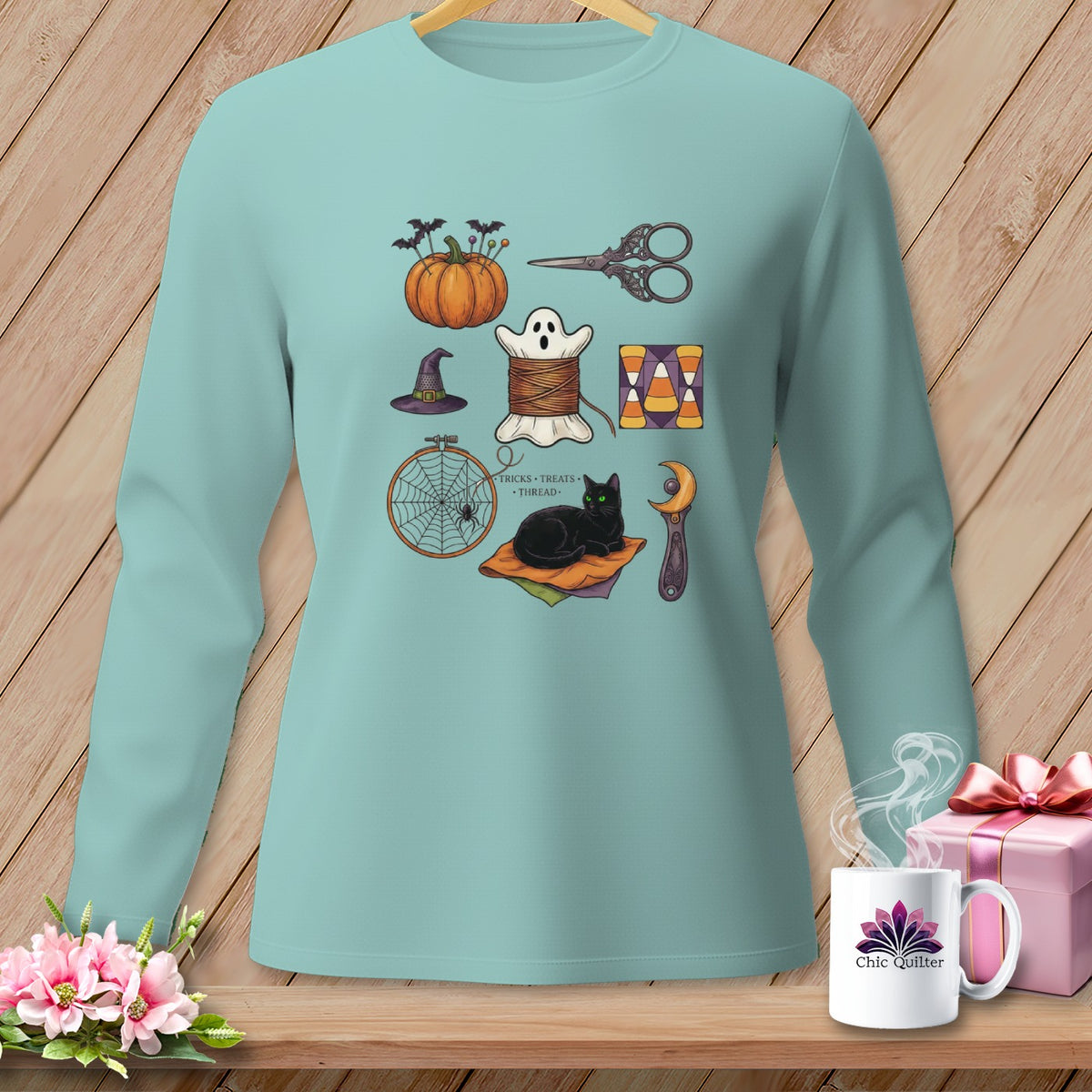 Teal long-sleeve shirt with Halloween sewing motifs including a black cat.