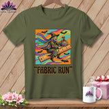 Green t-shirt with a colorful graphic of a witch riding a ruler, bats, and text 