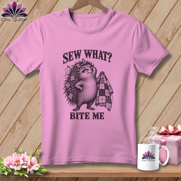 Pink t-shirt with a graphic of a hedgehog holding a quilt and the text Sew What? Bite Me.