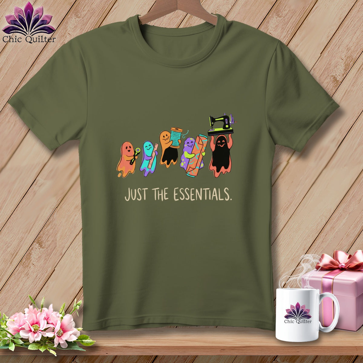 Olive green t-shirt with ghosts holding sewing items and text "JUST THE ESSENTIALS."