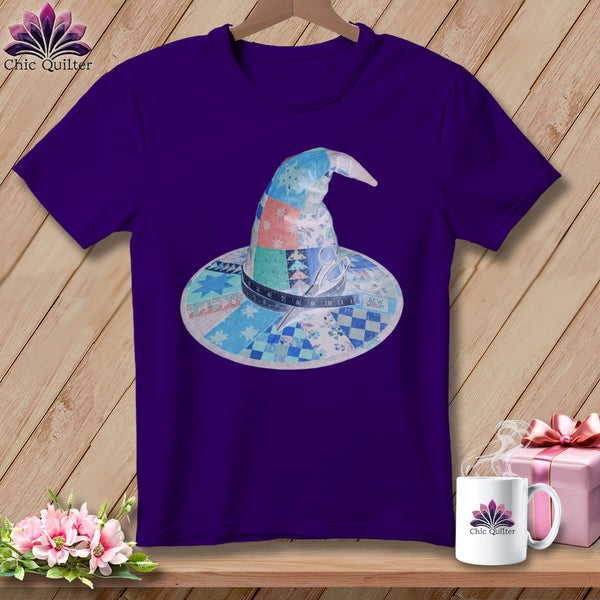 Purple t-shirt featuring a patchwork witch hat design with scissors and measuring tape.