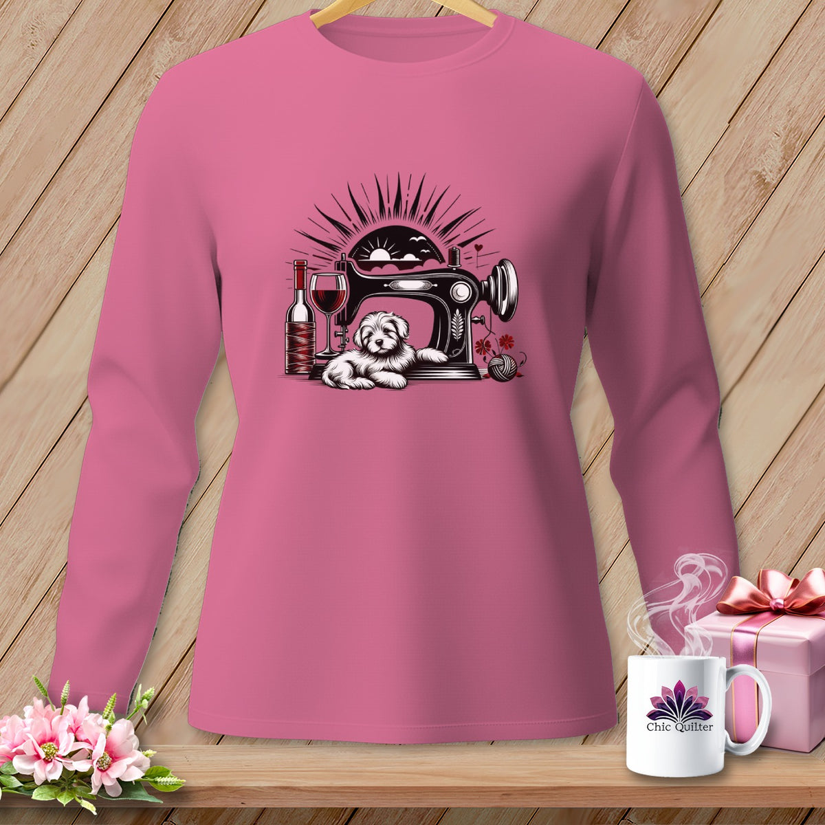 Pink long-sleeve shirt with sewing machine, dog, wine, and yarn graphic.