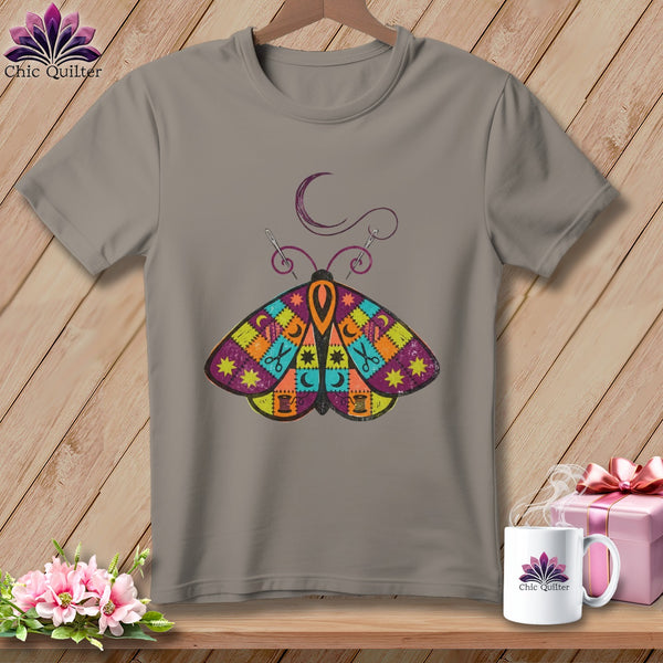 Gray t-shirt with a colorful patchwork moth graphic and sewing-themed elements.