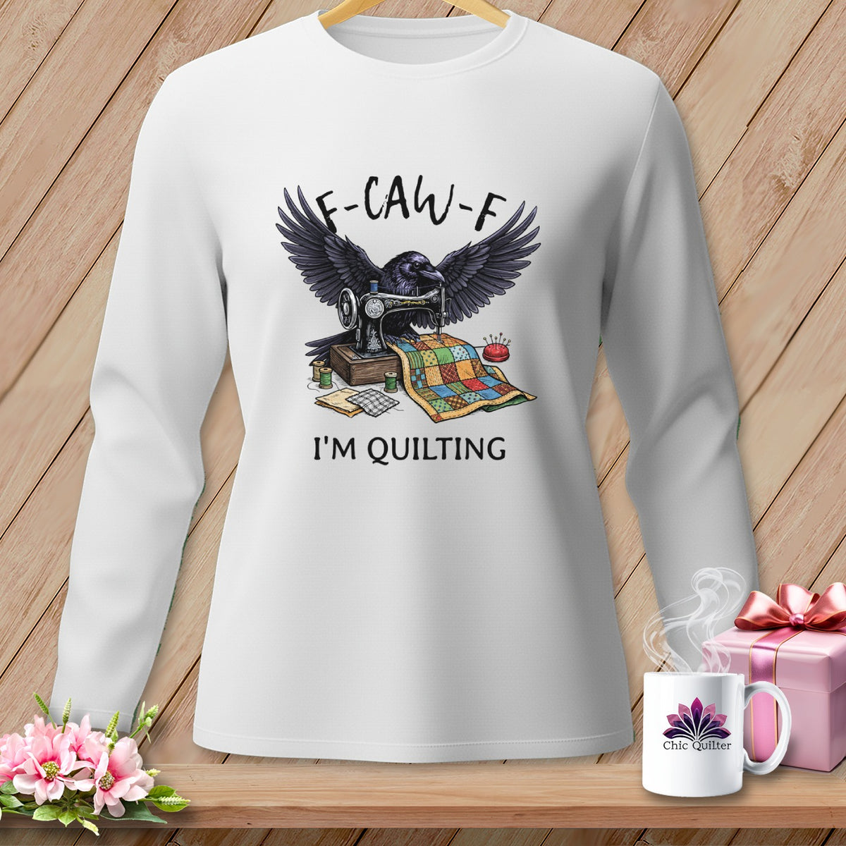 White long-sleeve shirt with crow sewing a quilt, "F-CAW-F" and "I'M QUILTING" text.