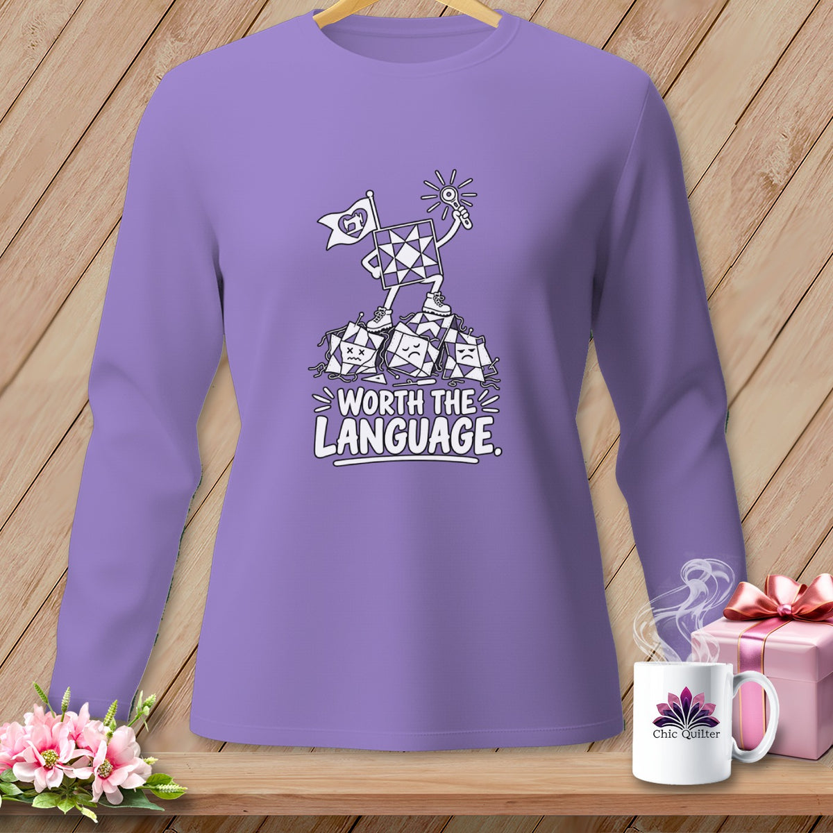 Purple long-sleeve shirt with cartoon quilt blocks and text "Worth the Language".