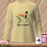 Light yellow long-sleeve shirt with graphic: woman, cat, quilt, and text 