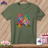 Olive green crewneck t-shirt featuring two colorful, patterned owls perched on a branch, holding sewing tools.