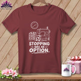 Maroon t-shirt with sewing machine, fabric, and text 